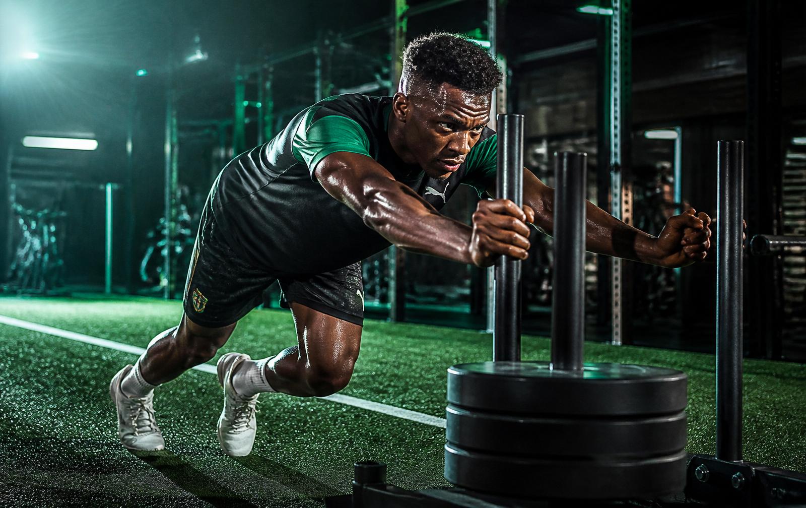 Player performing sled push in the strength and conditioning gym